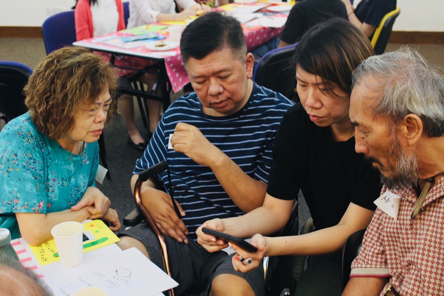 A speech therapist volunteer supporting the group conversation with technology